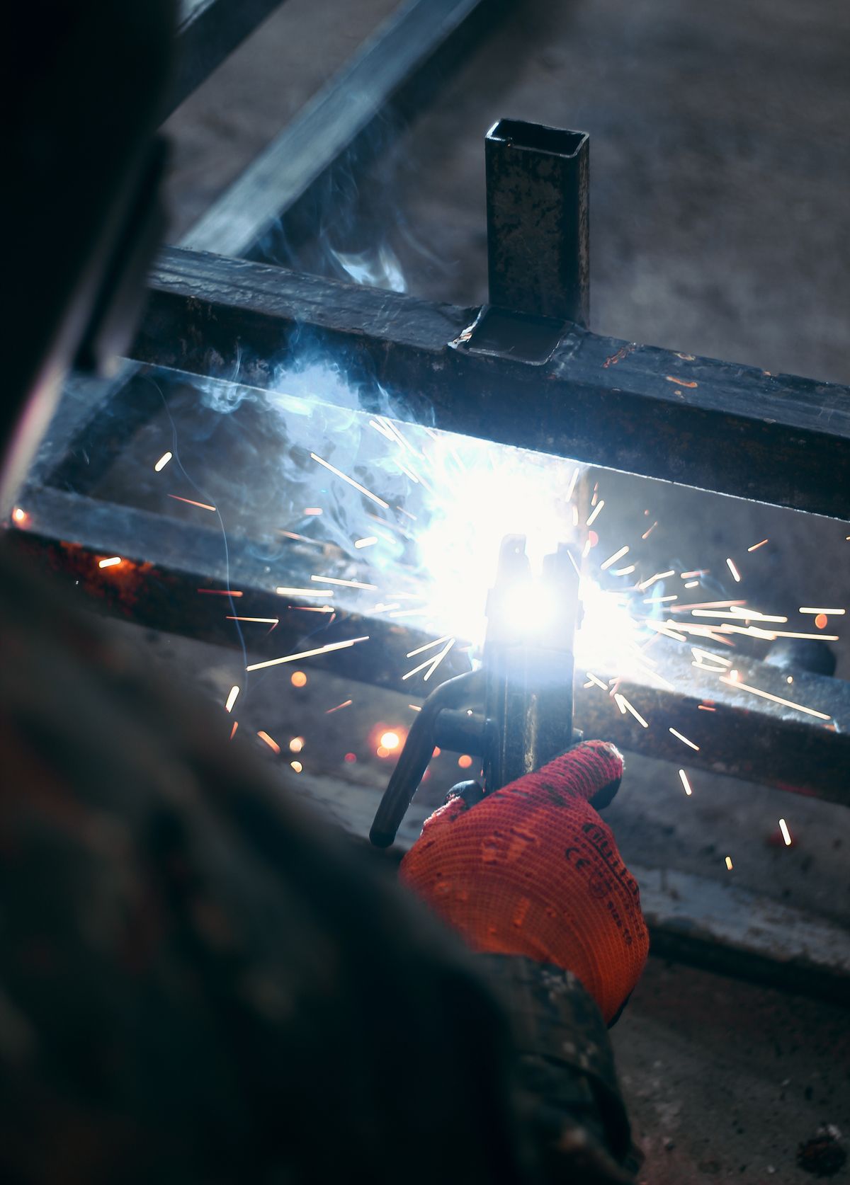 Welder fabricating steel with sparks flying